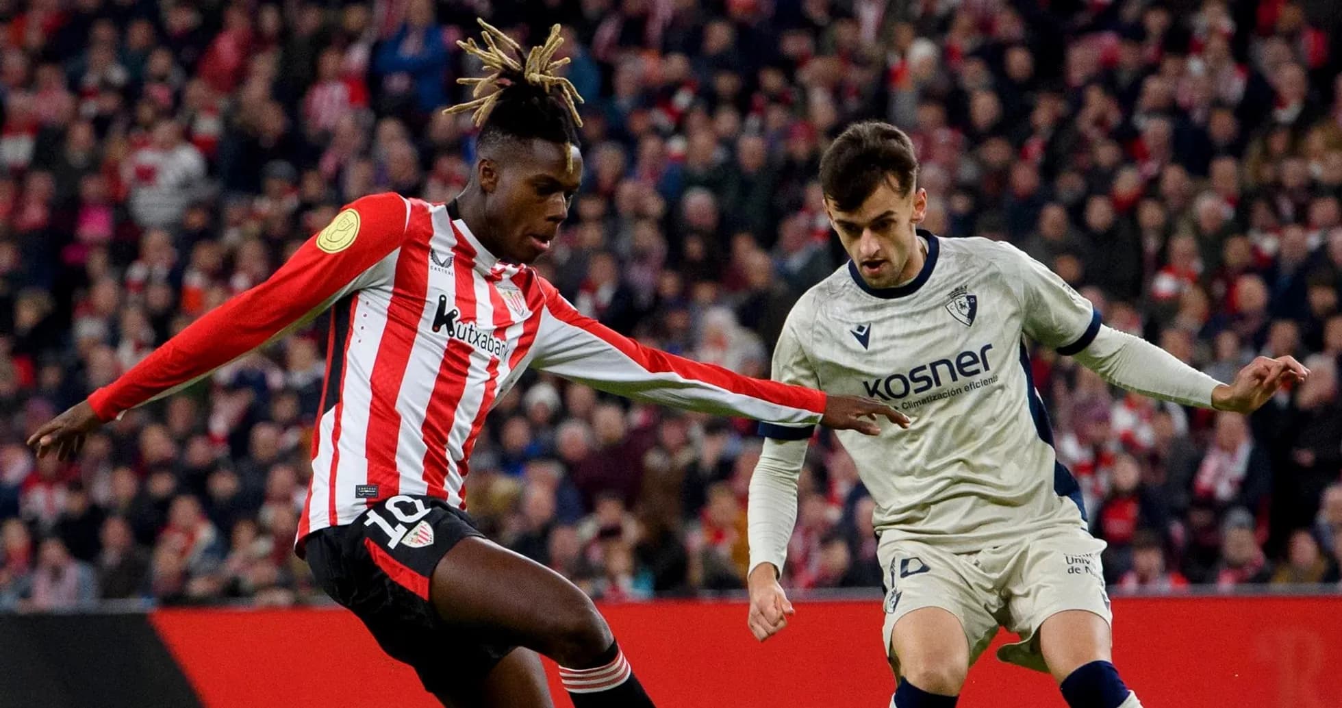 Athletic Club player challenging Osasuna opponent