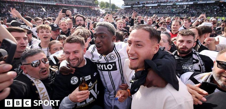 Fans celebrating with players in crowded stadium