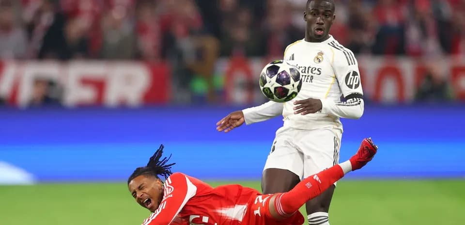 Player falling as opponent prepares to kick ball