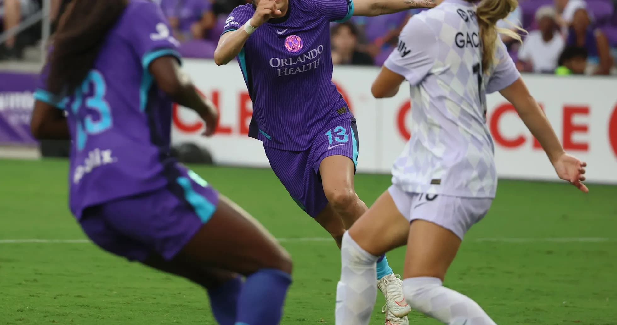 Orlando Pride player evading Portland Thorns defender