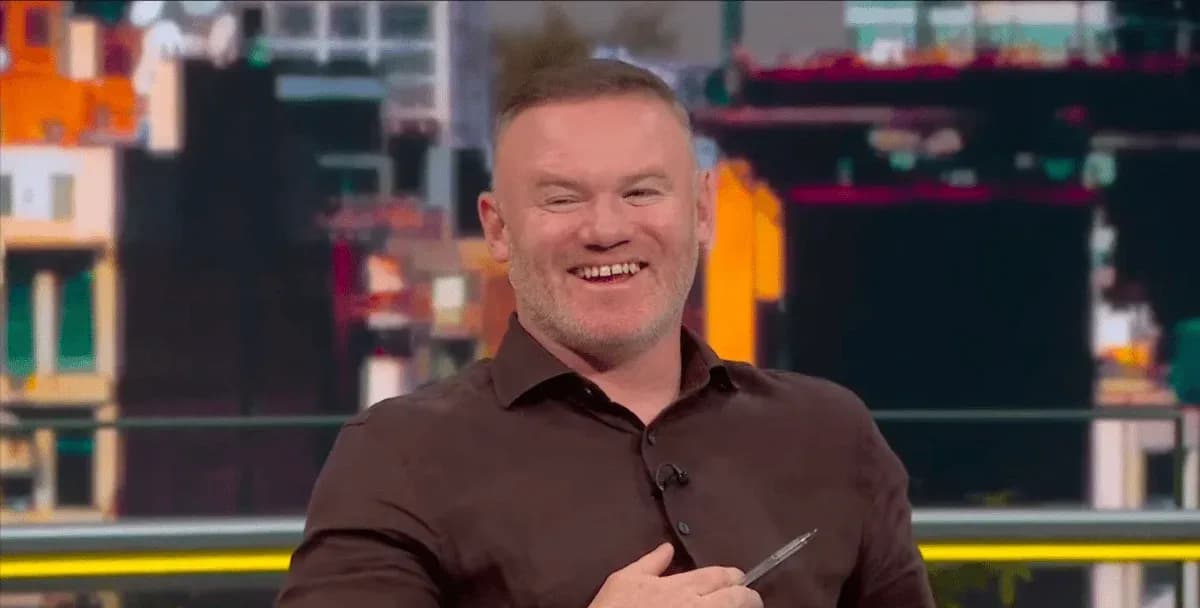 Man smiling while holding a pen on set