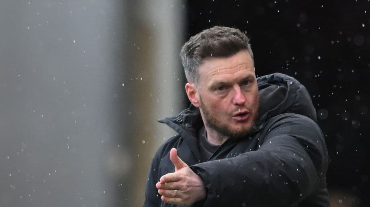 Coach gesturing during a rainy match