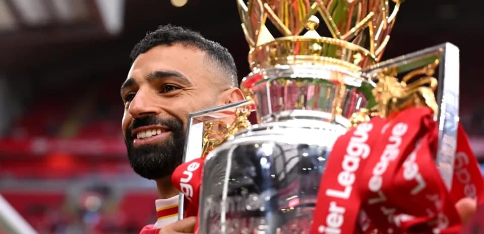 Player holding Premier League trophy with celebration