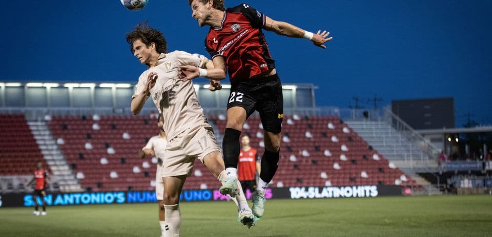 Player heading the ball during FC Tulsa match
