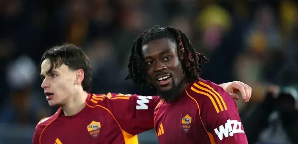 Two AS Roma players celebrating together on pitch