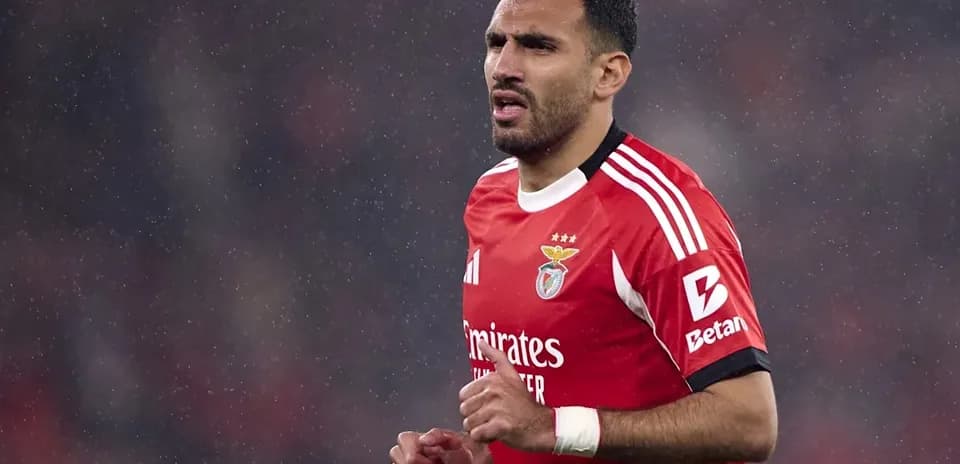 Benfica player running in rain during match