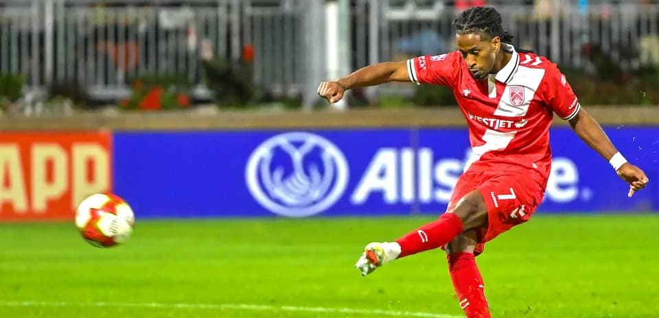 Player kicking the ball during Cavalry FC match