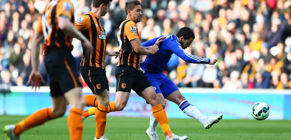 Chelsea player dribbling against Hull City defenders