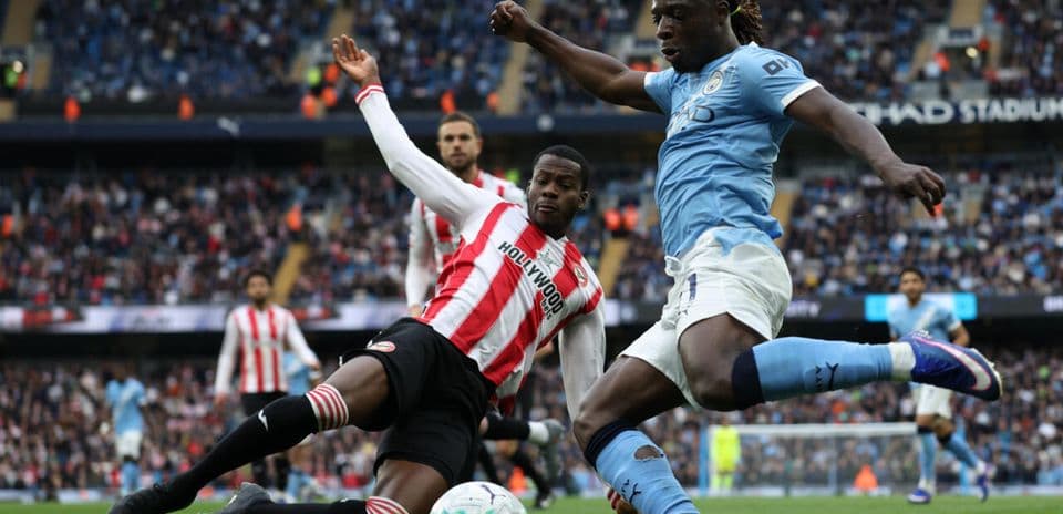 Player sliding tackle during match at Etihad Stadium