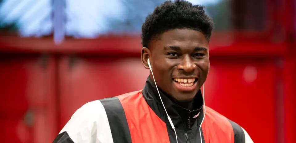 Player smiling while wearing earphones indoors