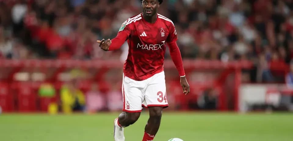 Player in red kit controlling the ball on field