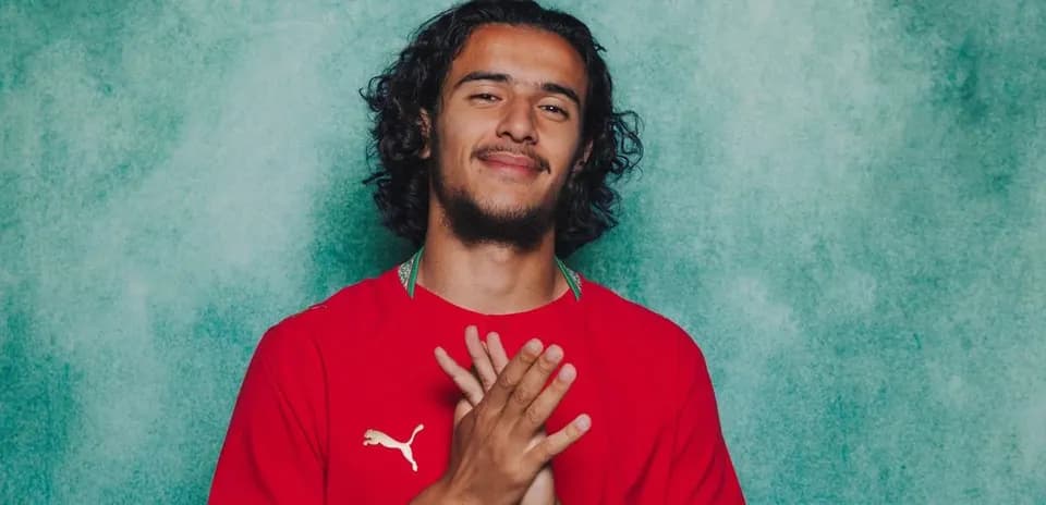 Player in red jersey posing with clasped hands