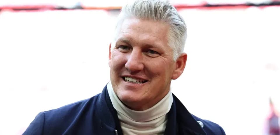 Former player smiling in a stadium setting