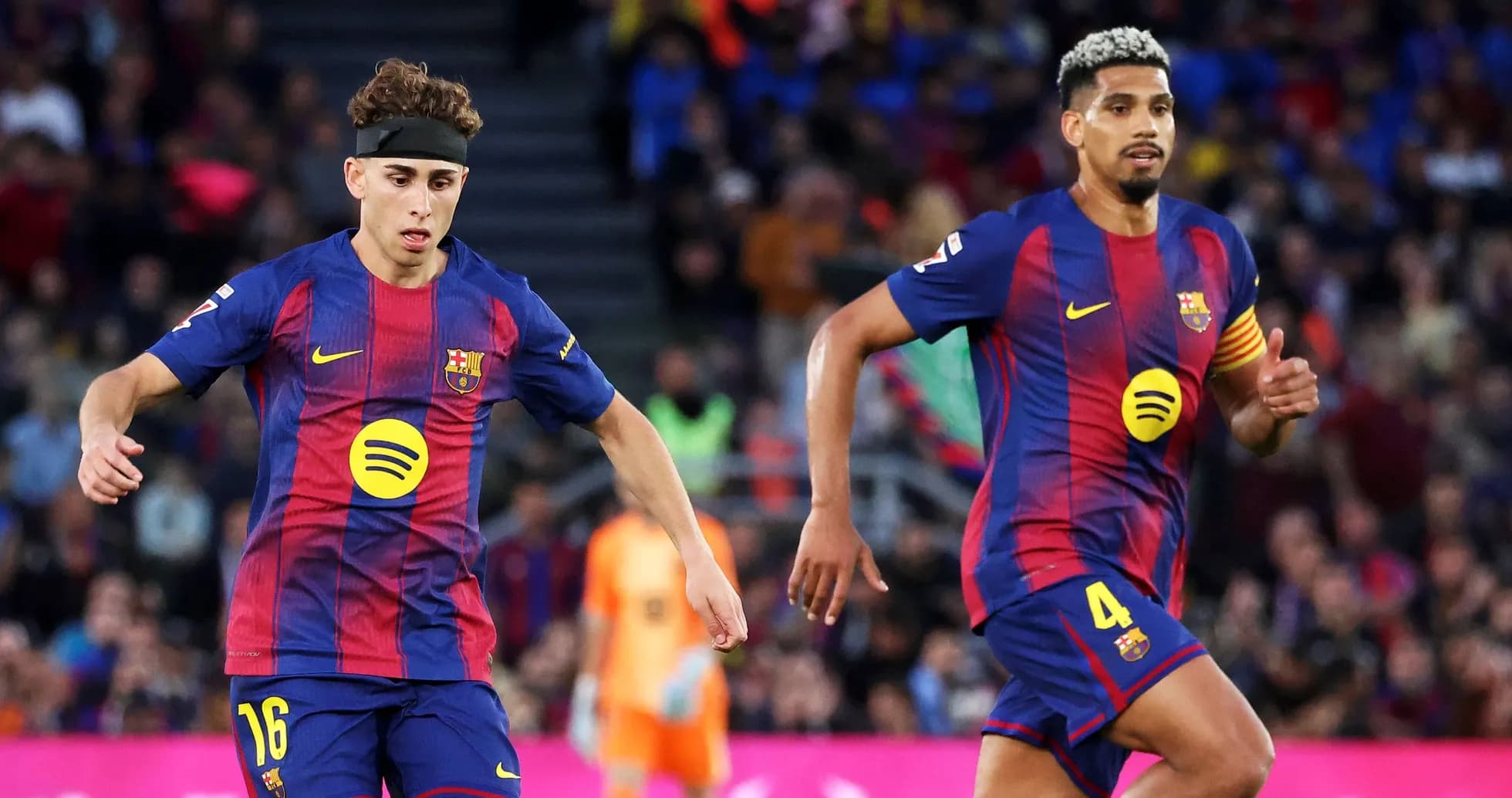 Two FC Barcelona players running on the pitch