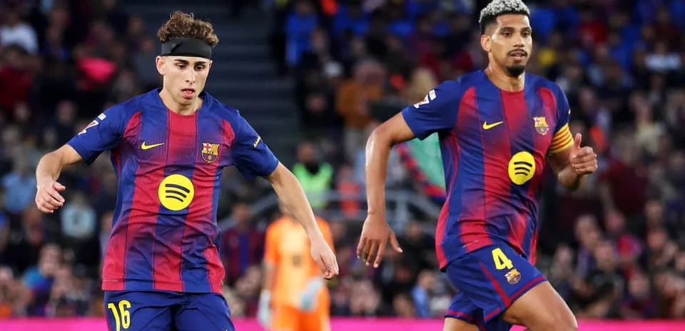 Two FC Barcelona players running on the pitch