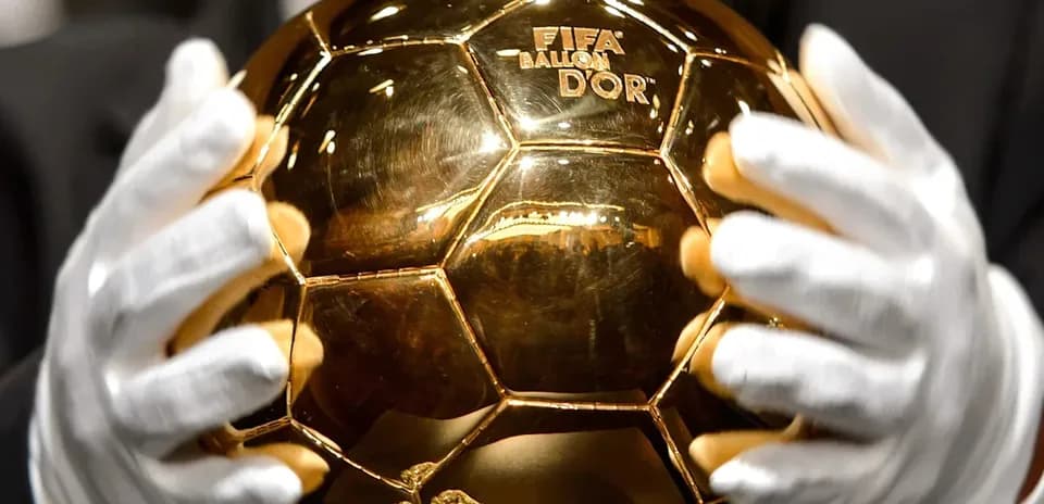 Person holding the FIFA Ballon d'Or trophy