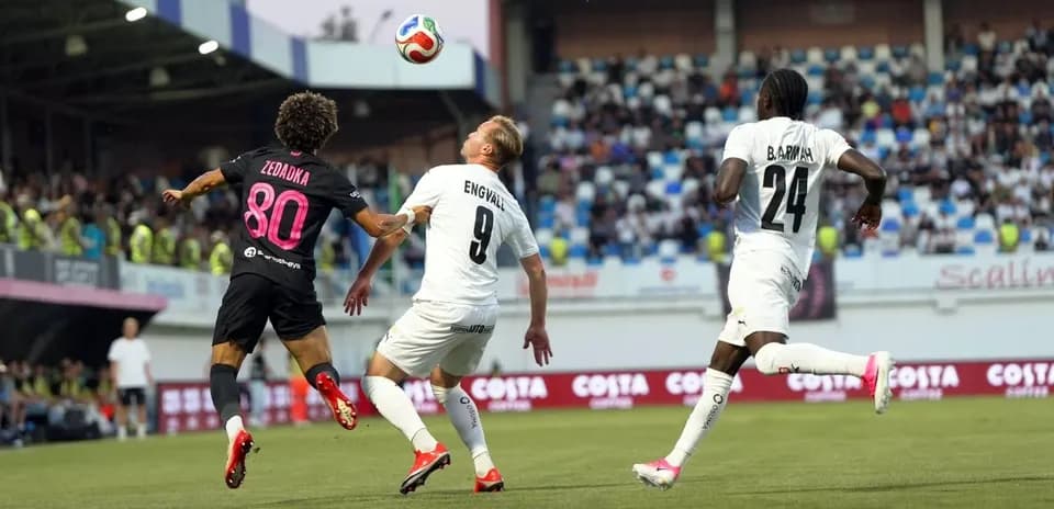 Players contesting for the ball in UEFA match