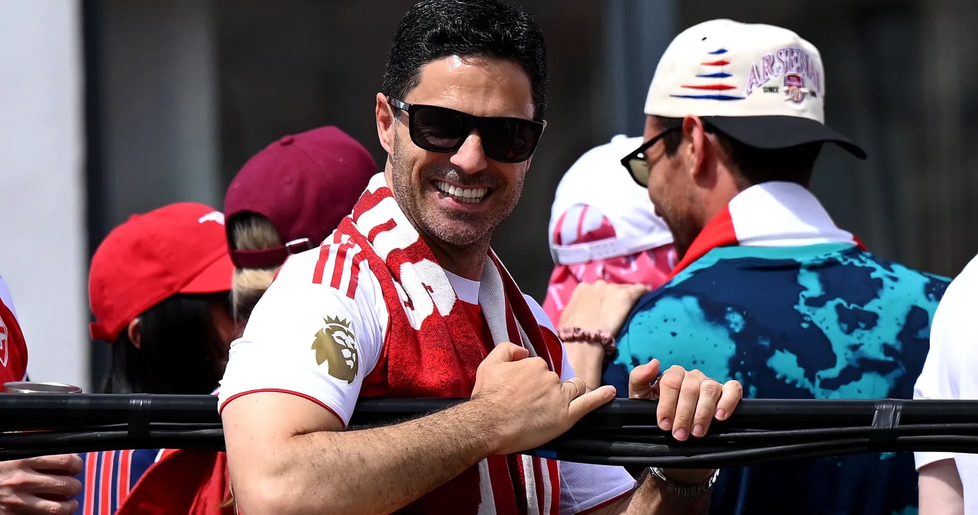 Man smiling and wearing an Arsenal scarf at event