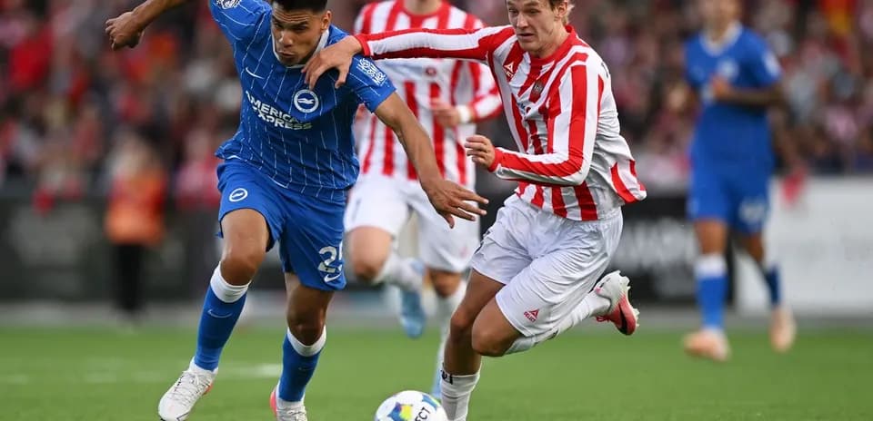 Player in blue evading tackle from opponent in red