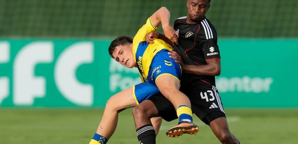 Player in yellow being tackled by opponent in black