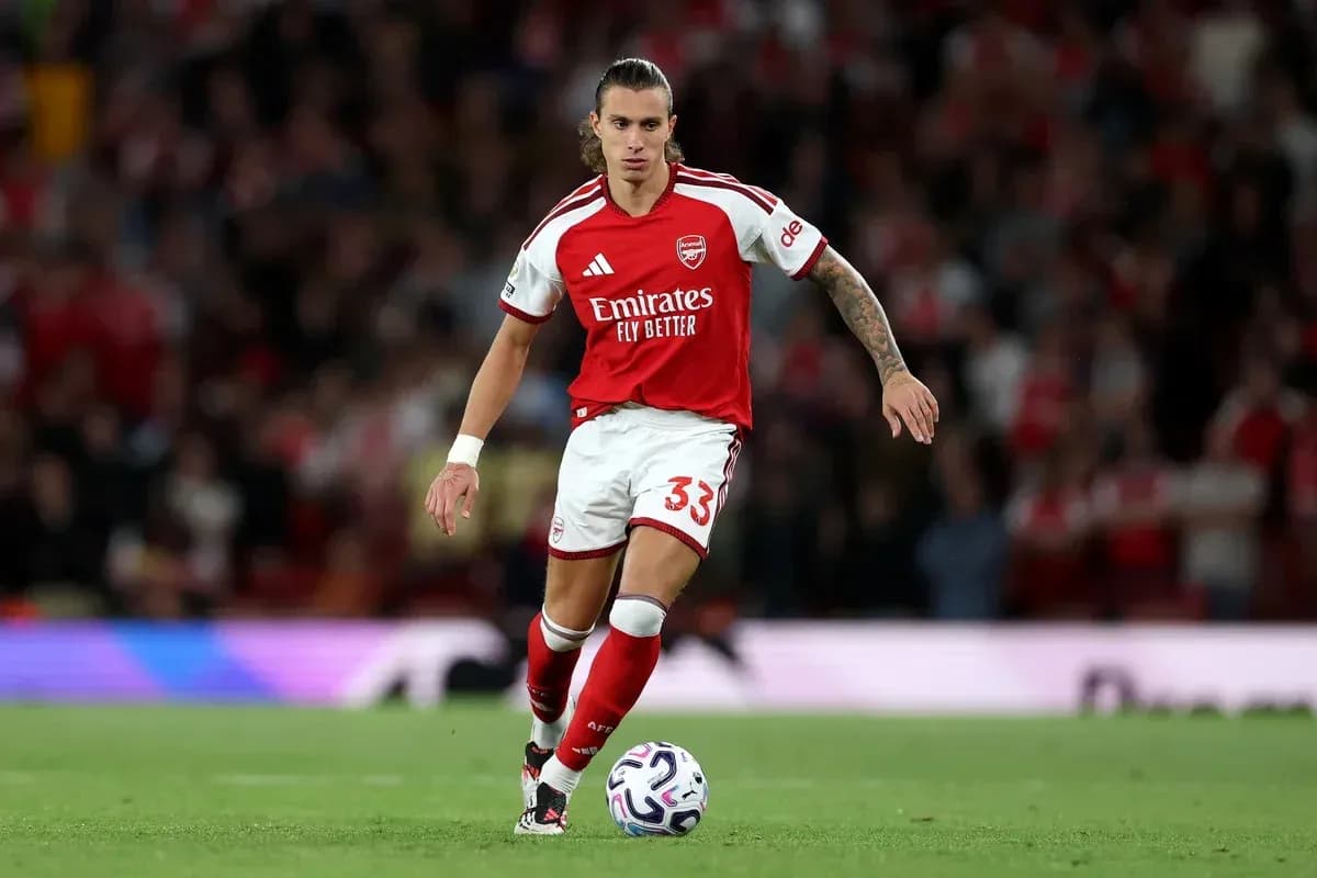 Player in Arsenal kit running with the ball