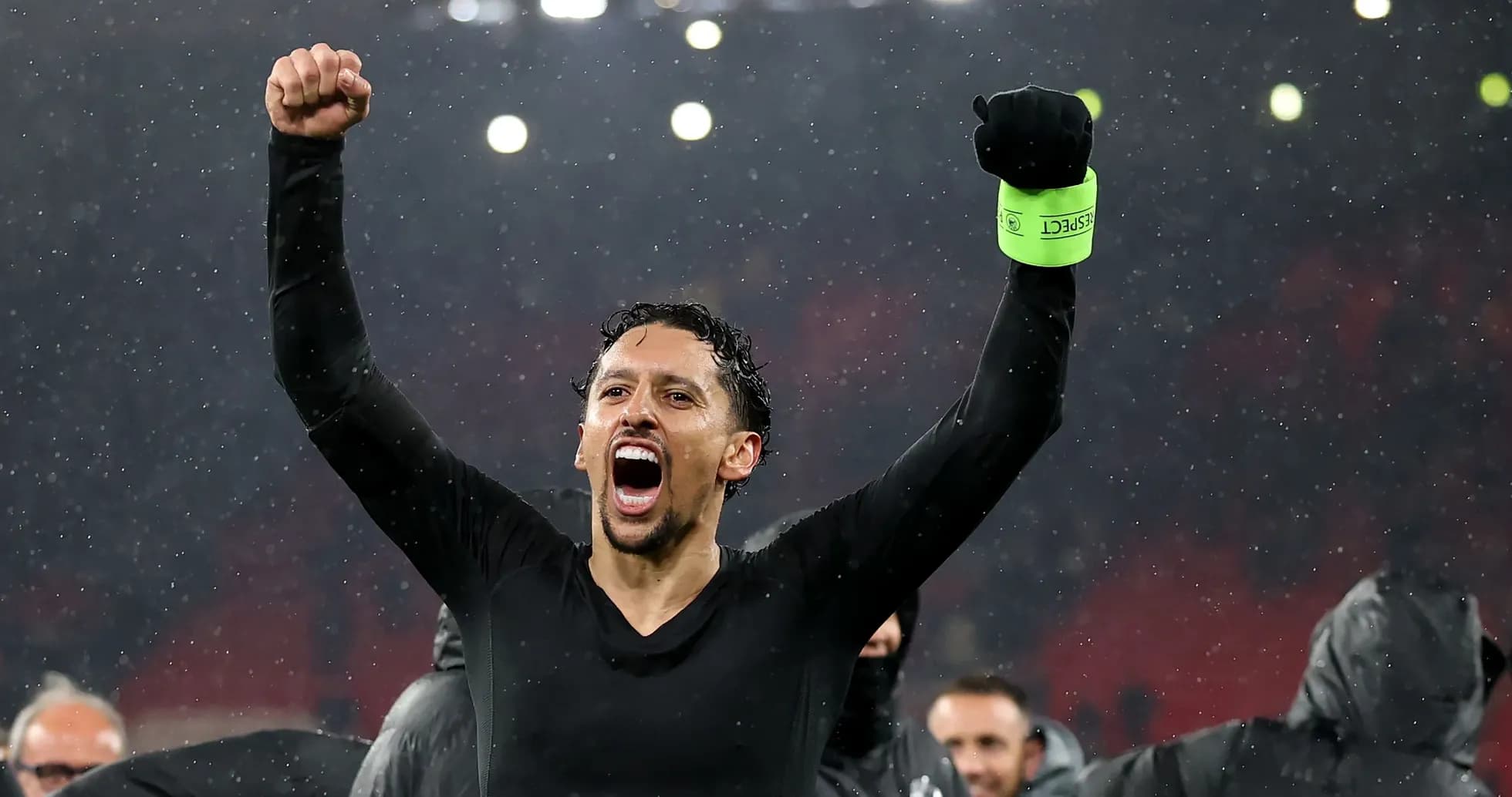 Player celebrating with raised fists in rain