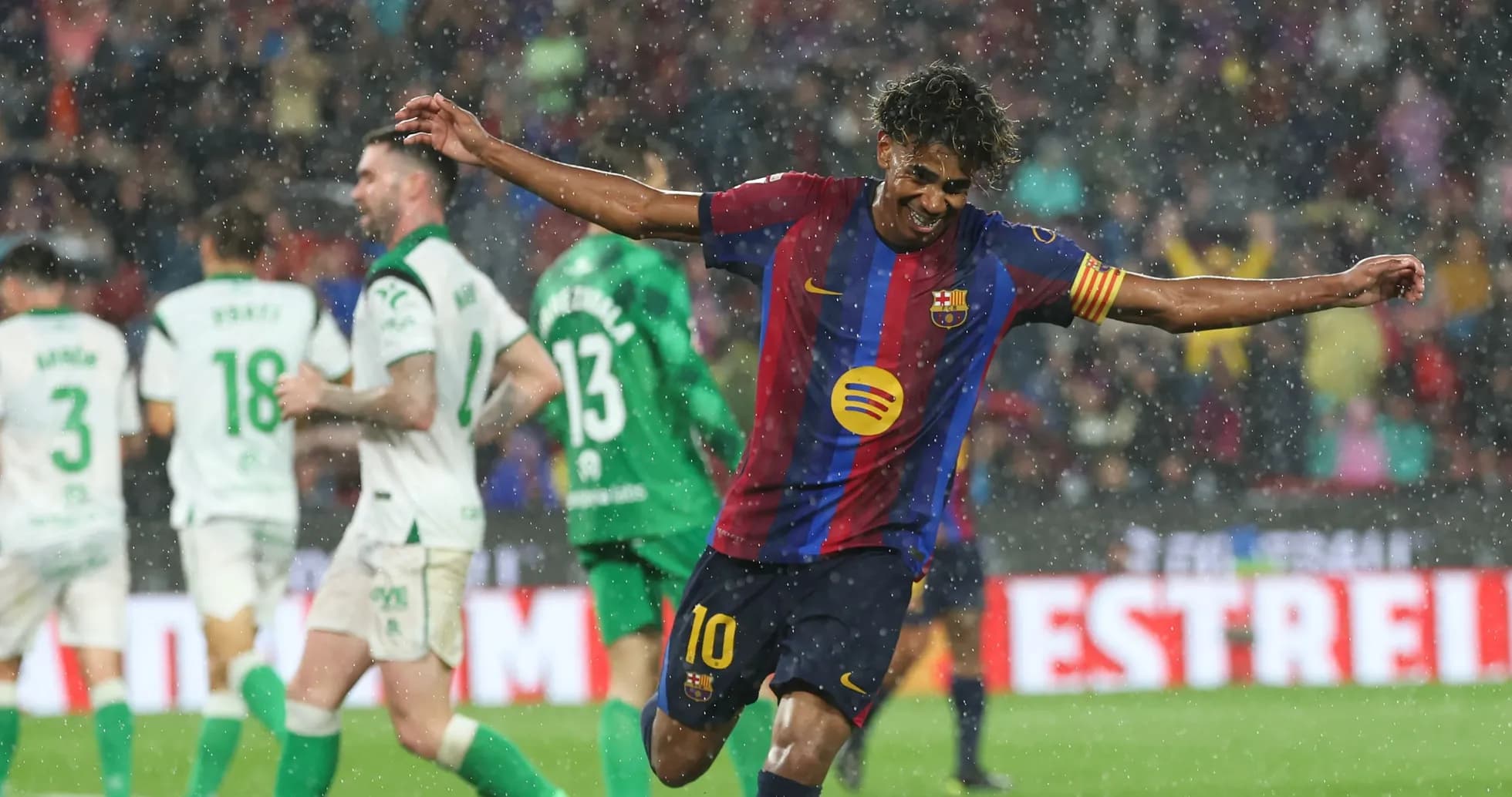 Barcelona player celebrating goal in rainy match