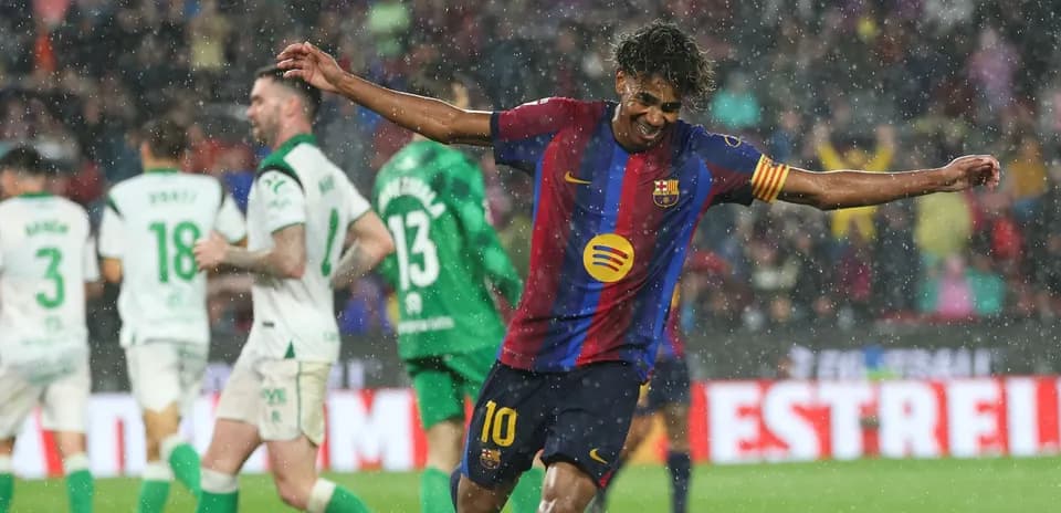 Barcelona player celebrating goal in rainy match