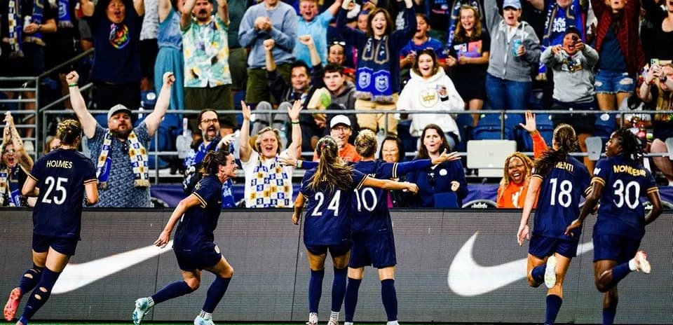Seattle Reign FC celebrating a goal with fans