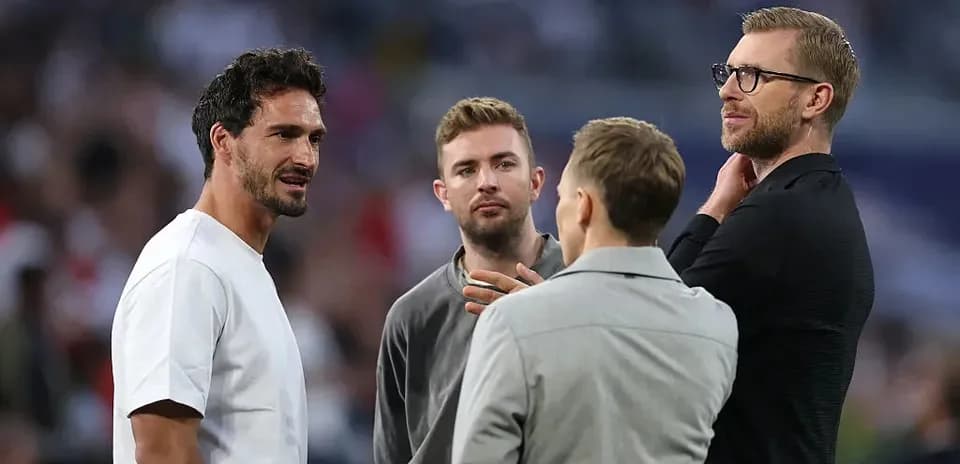 Four men conversing on the football field