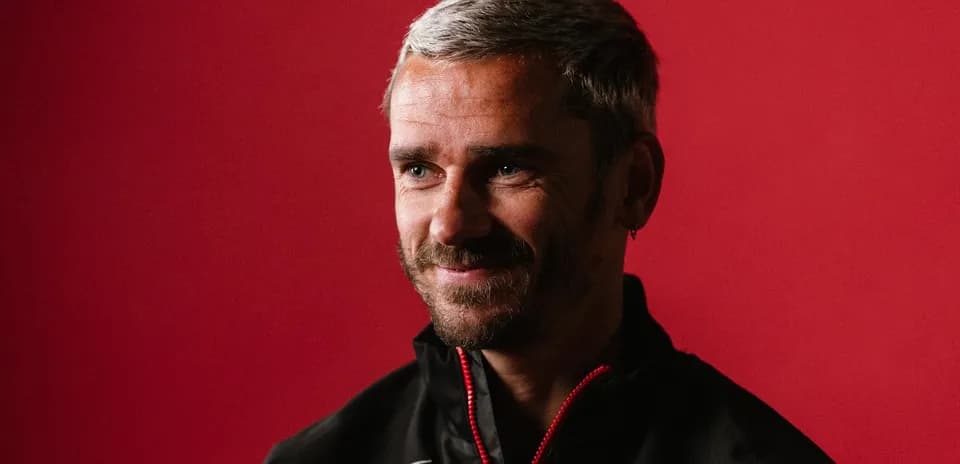 Man smiling in a black jacket against red background
