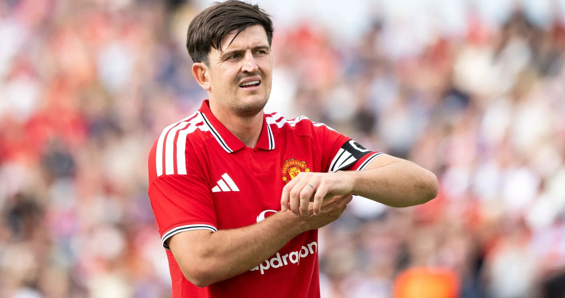 Player in Manchester United jersey adjusting wrist during match