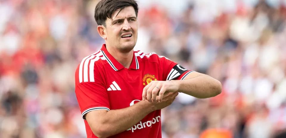 Player in Manchester United jersey adjusting wrist during match