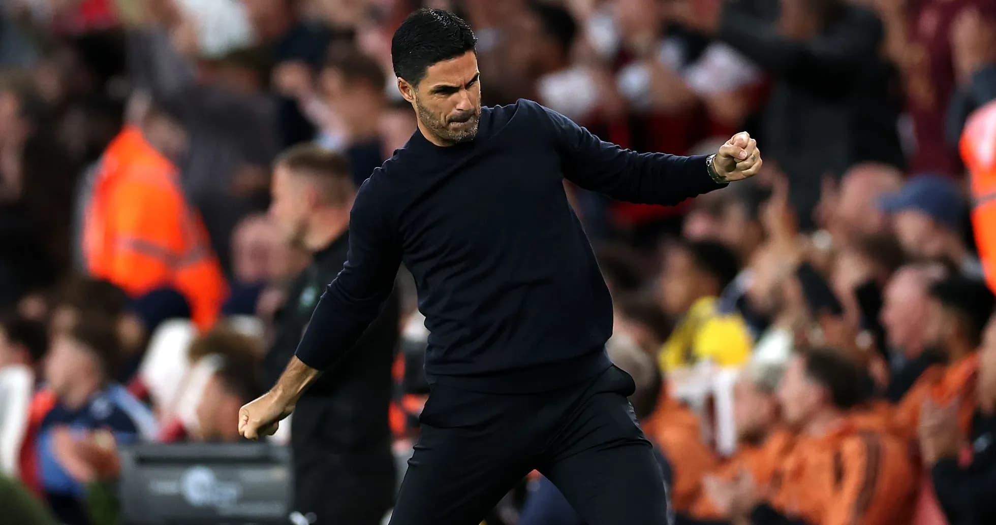 Manager celebrating in front of cheering crowd