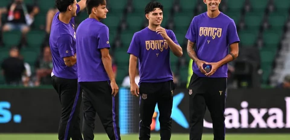 Players in purple shirts warming up on field