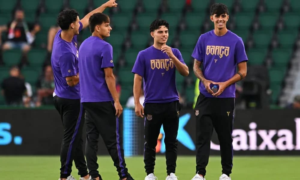 Players in purple shirts warming up on field