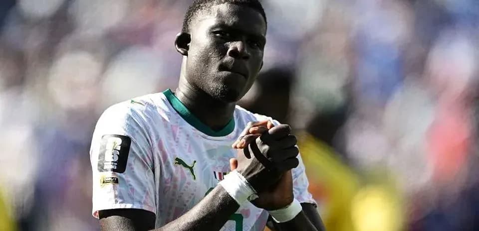 Player in white jersey with clasped hands on field