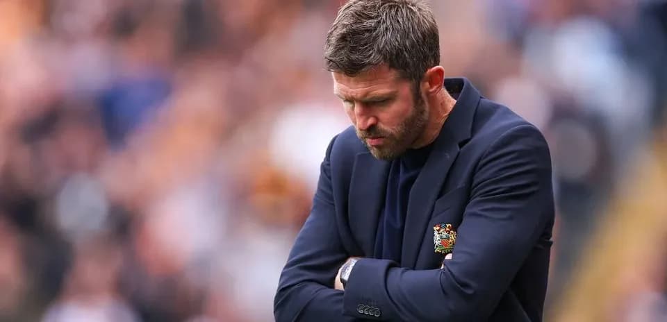 Coach with head down during match