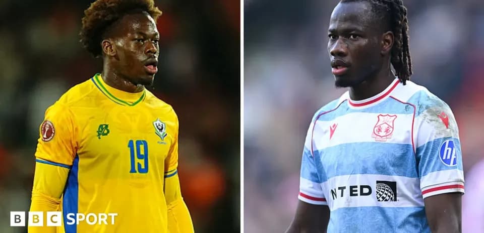 Two football players in different team kits on field