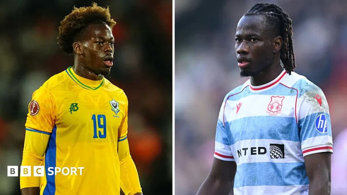 Two football players in different team kits on field