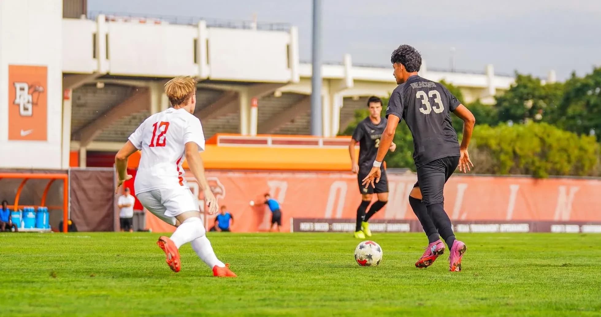 Player 12 challenges player 33 for the ball