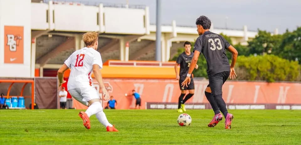 Player 12 challenges player 33 for the ball