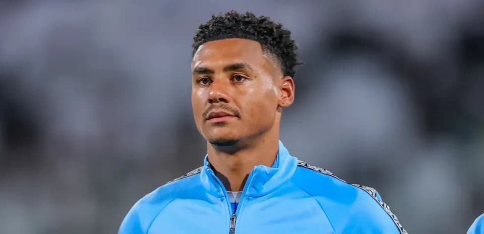 Player in blue training jacket on field