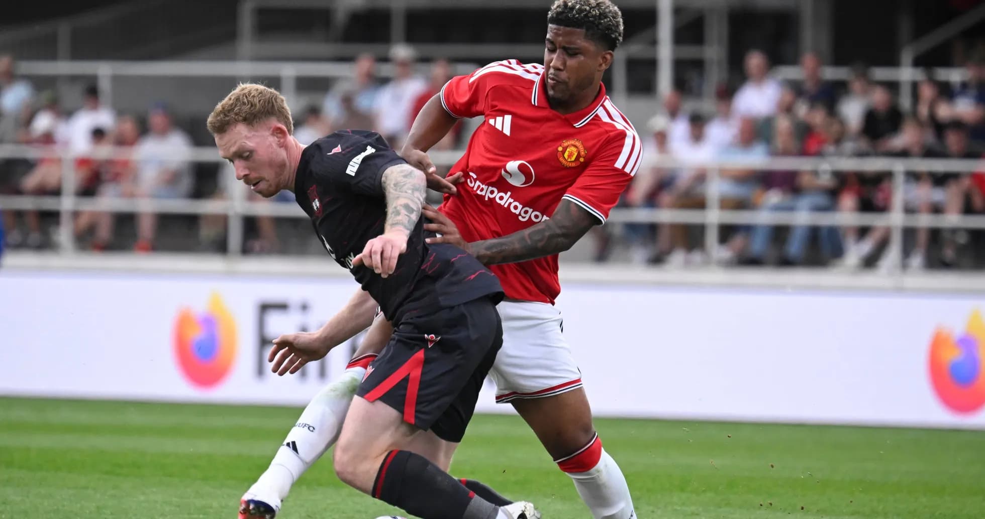 Player from Manchester United tackling opponent on field