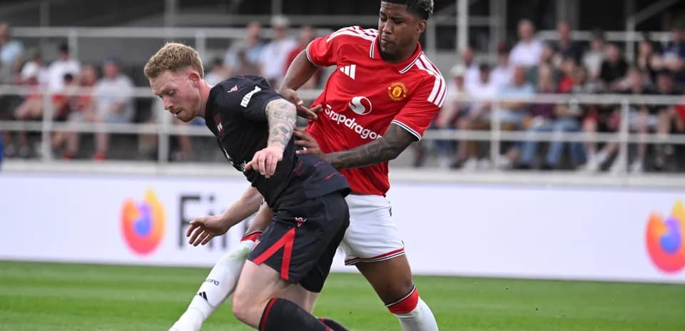 Player from Manchester United tackling opponent on field