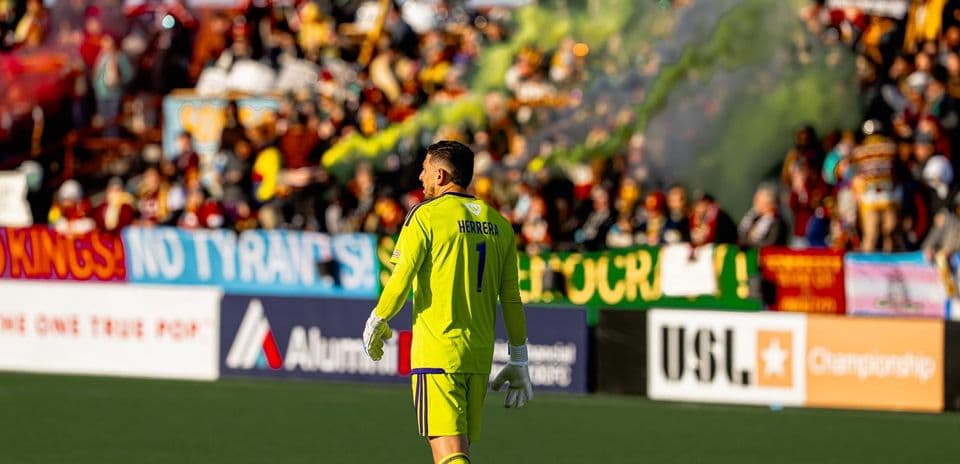 Goalkeeper during match with fans in background