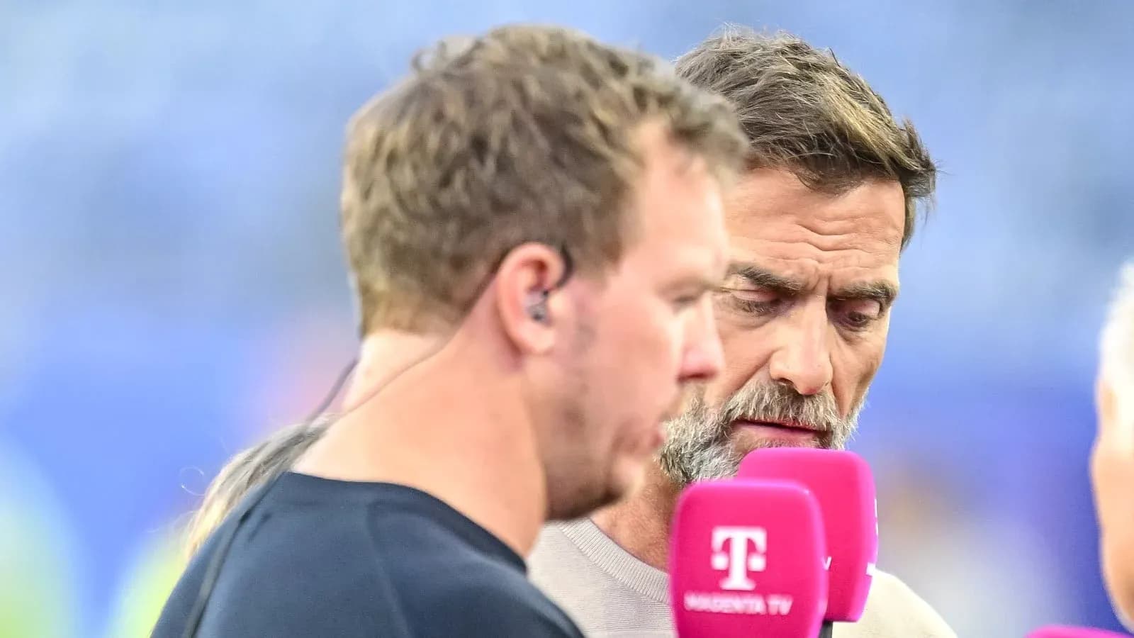 Two sports analysts discussing with microphones in hand