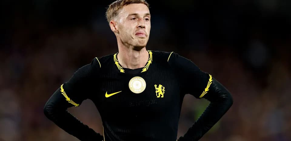 Player in black kit during match with Chelsea emblem
