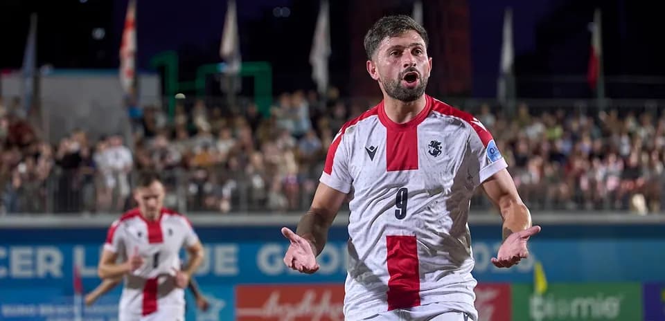 Player celebrating on beach soccer field during match