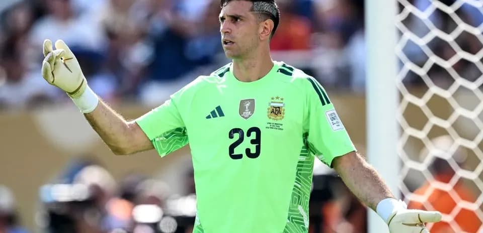 Goalkeeper in green kit directing play on field
